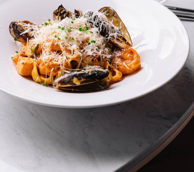 Gurme midye makarnası lüks bir yemek masasında servis edilir. Yakın çekim.