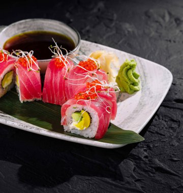 Bambu yaprağında taze ton balıklı gurme suşi rulosu, soya sosuyla servis ediliyor.
