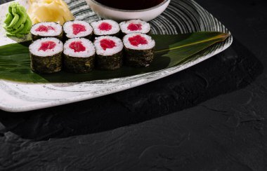 Bambu yaprağında wasabi, zencefil ve soya sosuyla servis edilen ton balıklı suşi ruloları.