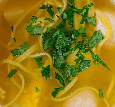 Maydanozlu makroyla süslenmiş taze tavuklu şehriye çorbası.