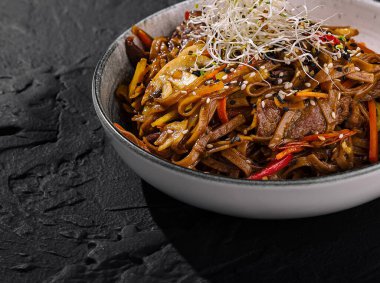 Şehriyeli ve gevrek sebzeli, lahanayla süslenmiş tuzlu biftek kızartması.