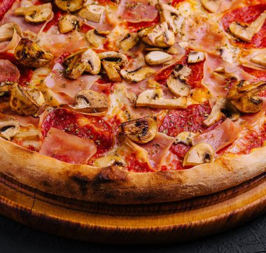 pizza with ham, salami and mushrooms close up clipart