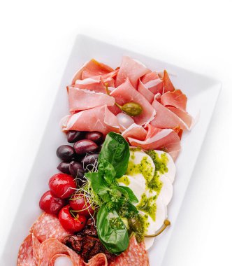 Beyaz bir tabakta çeşitli sosis ve peynir çeşitlerinin üst görünümü