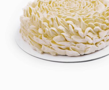 Güzel borulu beyaz tereyağlı Rosette pastası, beyaz arka planda basit bir duruşta.