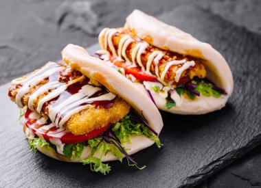 Koyu bir arka planda taze soslu leziz tavuk burger.