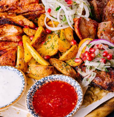 Izgara et, taze sebze ve sos içeren renkli bir Gürcü mutfağı.