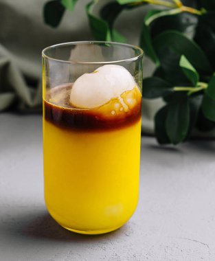 Katmanlı tropik kokteyl ve buz küreli zarif bardaklar.