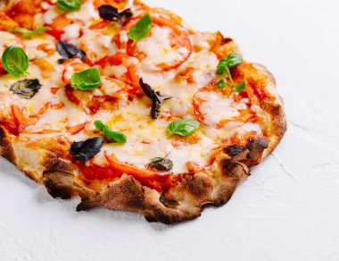 Erimiş peynir ve fesleğenli ev yapımı margherita pizzası.