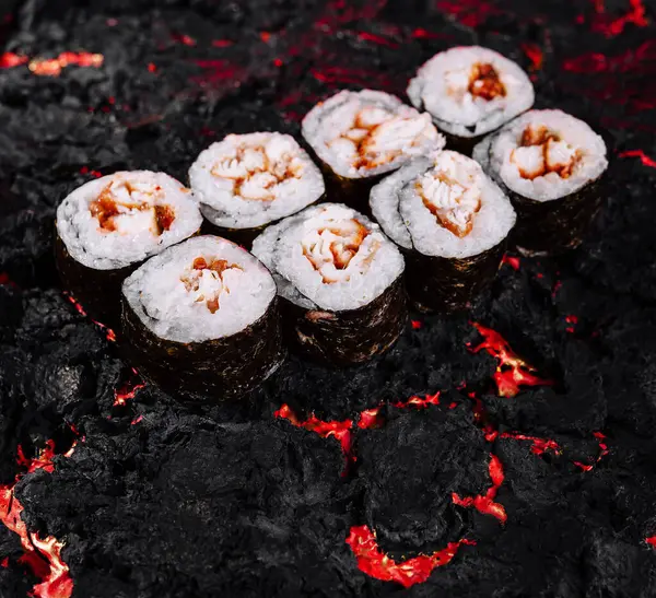 stock image Elegant sushi rolls artfully placed on a dramatic, fiery, lava-inspired background