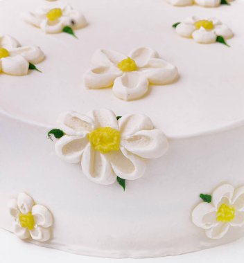 Nefis ve zarif beyaz papatya pastası ve el yapımı şeker çiçekleri. Doğum günü veya düğün kutlaması için mükemmel. Lezzetli bir gurme pasta başyapıtı makro