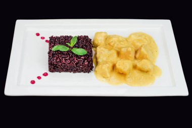 Zarif kremalı tavuk köri tabağı yanında naneli siyah pirinç aroması.