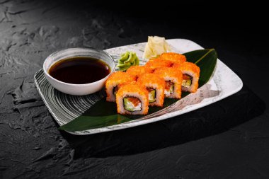 Soya sosu, zencefil ve wasabi ile servis edilen tobiko soslu iştah açıcı California usulü suşi.