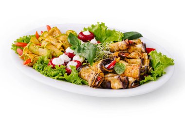 Canlı ızgara sebze tabağı. Parlak, beyaz bir tabakta otlarla süslenmiş.