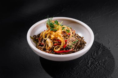 Sebzeli ve tohumlu gurme şehriye. Koyu dokuda beyaz bir kasede servis ediliyor.