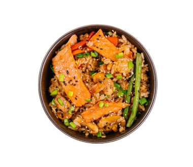 Beyaz arka planda izole edilmiş, sebzeli, lezzetli bir somon teriyaki pirinç kasesinin üst görüntüsü.