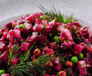 Çağdaş bir tabakta servis edilen dereotlu ve bezelyeli canlı pancar salatası.