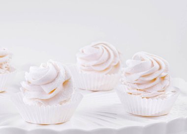 Pembe ve beyaz kremalı beş gurme kek klasik beyaz pasta standı üzerinde pürüzsüz bir arka plan