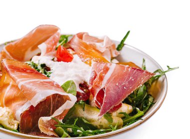 Beyaz arka planda prosciutto, roka ve mozzarella ile iştah açıcı salata.