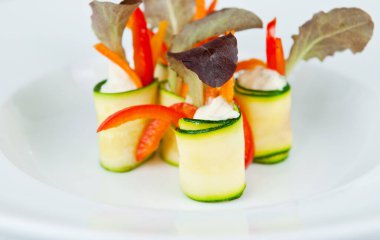 Temiz, beyaz bir tabakta sunulan taze sebze kanapelerinden oluşan gurme çeşidi.