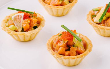 Beyaz bir tabakta sunulan somon, havyar ve otlarla dolu nefis mezeler.