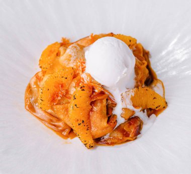 Zarif bir tabak kremalı makarna. Üstünde turunçgiller ve krema var.