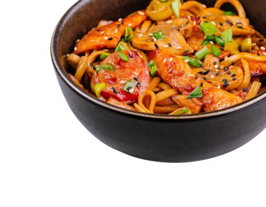 Renkli ve iştah açıcı tavuk. Kızarmış, siyah kasede servis edilen sebzelerle birlikte kızartılmış.