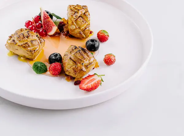 stock image Gourmet french toast with fresh berries and fruit coulis on a pristine white background