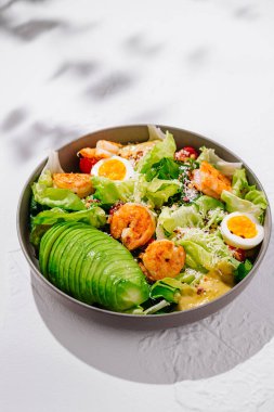Karidesli taze sezar salatası, marul, avokado, yumurta ve sezar soslu parmesan peyniri.