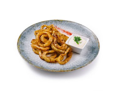 Bol yağda kızartılmış kalamar halkaları. Çağdaş bir tabakta servis edilen otlar ve baharatlarla çeşnilendirilmiş. Yanında beyaz sos da var.