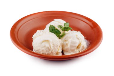 Üç kepçe vanilyalı dondurma, üzerinde bir tutam nane ile, kırsal kahverengi bir kasede eriyor.