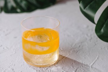 Sarı karışımı canlandırmak, tropikal yapraklarla beyaz desenli arka planda durmaktır.