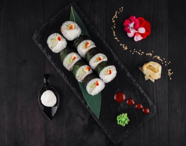 Siyah tabakta zencefil, wasabi ve soslu suşi.