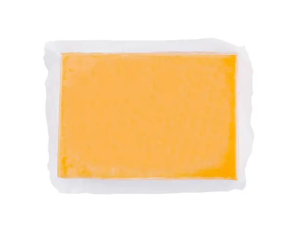 stock image Square block of cheddar cheese is vacuum sealed in plastic wrap to preserve freshness