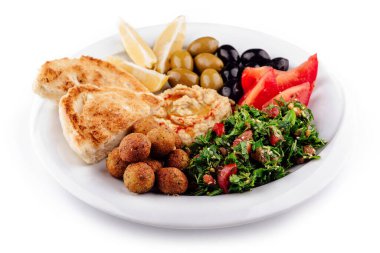 Lezzetli bir tabak Orta Doğu yemeği sunar Pide ekmeği, falafel, humus, tabu, zeytin ve domates
