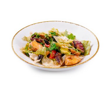 Beyaz arka planda izole edilmiş taze ahtapot, marul ve kızarmış ekmek salatası.