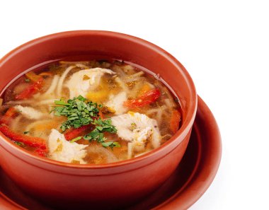 Çamur kasesi taze maydanozla süslenmiş tavuk çorbası ile dolu.