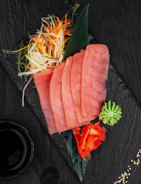 Soya sosu ve wasabi eşliğinde siyah taş tabakta güzel bir şekilde dizilmiş ton balıklı sashimi nefis bir aşçılık deneyimi yaratıyor.