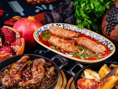 Izgara kuzu pirzola ve domates salatası ahşap bir tabakta diğer Gürcü mutfağıyla servis edilir.