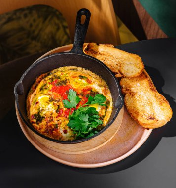 Sebzeli ve otlu taze pişmiş yumurtalar, kafeteryada kızarmış ekmek ve ahşap tepside servis edilir.