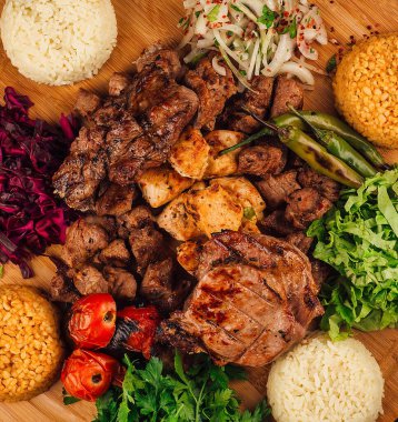 Tahta tahtada sebzeli ve pirinçli ızgara et çeşitleri. Lezzetli ve lezzetli bir yemek.