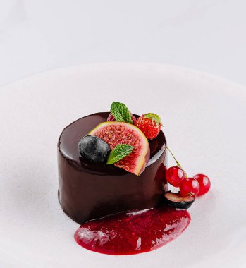 Çürümüş çikolata tatlısı taze böğürtlen ve beyaz tabakta nane şekeri ile süslenmiş.