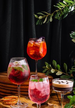 Diverse collection of crafted cocktails artistically presented against a dark, elegant backdrop with greenery clipart