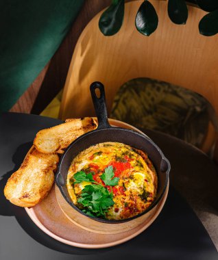 Sebzeli ve otlu taze pişmiş yumurtalar, kafeteryada kızarmış ekmek ve ahşap tepside servis edilir.