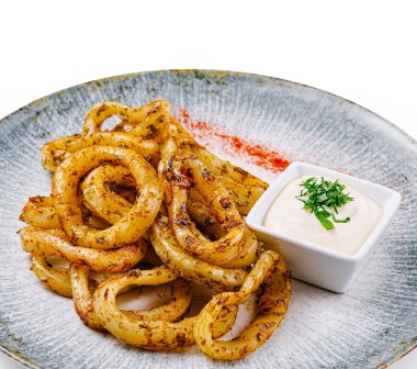 Bol yağda kızartılmış kalamar halkaları. Çağdaş bir tabakta servis edilen otlar ve baharatlarla çeşnilendirilmiş. Yanında beyaz sos da var.