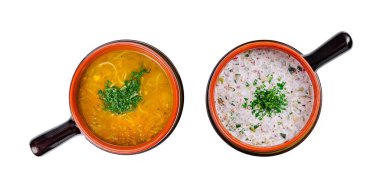 Sıcak tavuk çorbası ve dereotuyla süslenmiş soğuk okroshka çorbasıyla dolu iki kil kap.