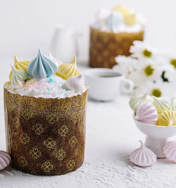 stock image Traditional easter kulich cake topped with pastel meringues and sprinkles, with festive decor