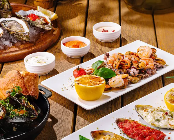 Görkemli Akdeniz yemekleri serisi sanatsal olarak sıcak bir ahşap zemin üzerinde sunuluyor.