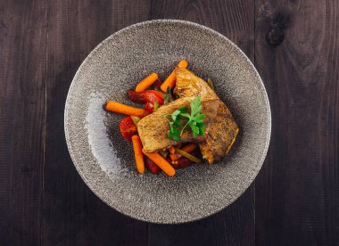 Havuç, domates, yeşil fasulye ve maydanozla servis edilen lezzetli ızgara balık filetosu.