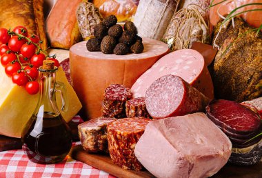 Artfully arranged selection of fine cheeses, meats, and bread on a classic checkered tablecloth