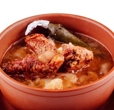 Et ve patatesli Aromatik çorba kil bir kasede servis edilir, kırsal ve lezzetli bir yemek deneyimi sunar.